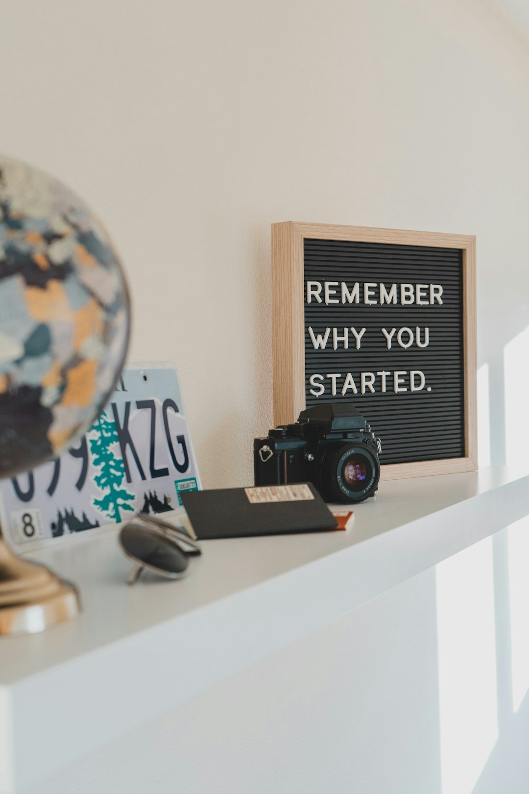 shallow-focus-photo-of-black-slr-camera-on-white-wooden-shelf-nskp7gwa-i0